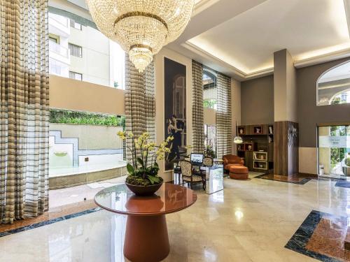 a large lobby with a table and a chandelier at Mercure Sao Paulo JK in Sao Paulo