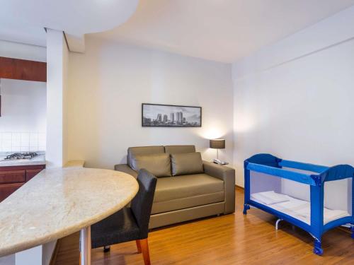 a living room with a couch and a table at Mercure Sao Paulo JK in Sao Paulo