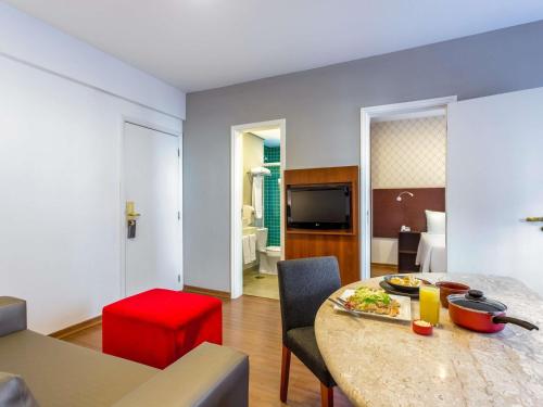 a room with a table with a plate of food on it at Mercure Sao Paulo JK in Sao Paulo