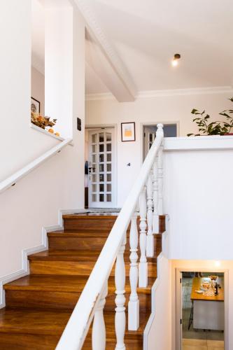 a staircase in a home with white walls and wood floors at Azurara Guesthouse in Azurara