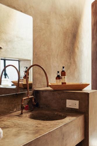 a bathroom sink with two bottles of alcohol on it at Casa Arrona Oaxaca in Oaxaca City