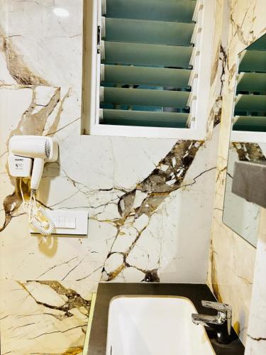a bathroom with a white sink and a window at Viman Vista The luxury studio near Pune airport in Pune