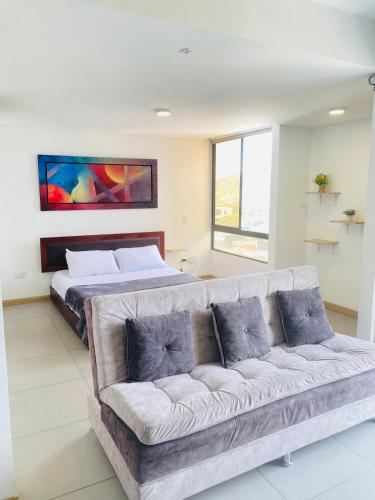 una sala de estar con un sofá y una cama en Rinconcito cafetero apto con Gym, Piscina y Wi-Fii, en Pereira