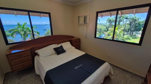 a bedroom with a bed and two large windows at Duplex 301C | Alter do Chão in Alter do Chao