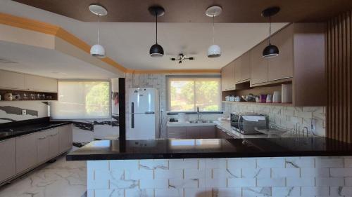a large kitchen with a refrigerator and a sink at Duplex 301C | Alter do Chão in Alter do Chao