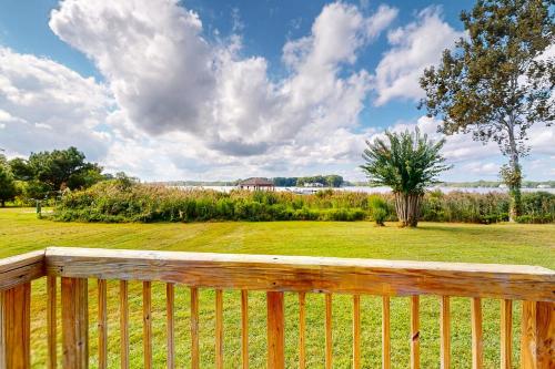 a wooden fence in front of a yard with a field at Sunkist & Salty in Ocean Pines