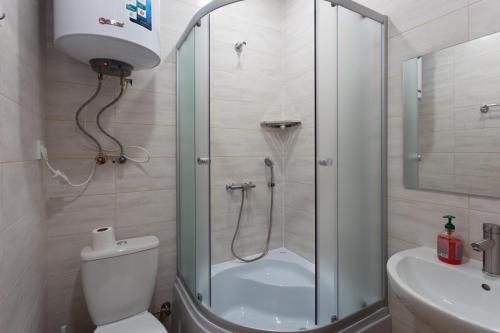 une salle de bains avec douche, toilettes et lavabo dans l'établissement Затишна квартира в центрі на Харківській набережній 3-3, à Kharkov