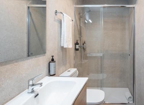 a bathroom with a shower and a sink and a toilet at LUTHIA Puerta del Sol in Madrid