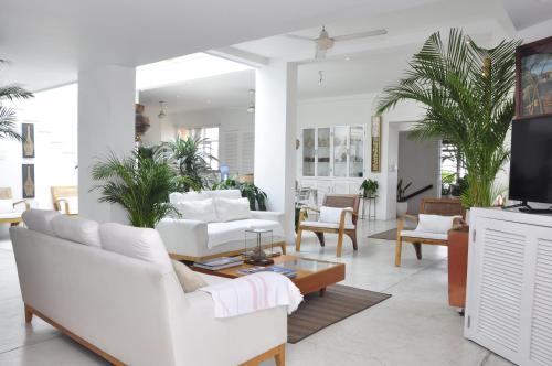una sala de estar con muebles blancos y palmeras. en Penthouse Caribbean View and private pool, Cartagena, en Cartagena de Indias