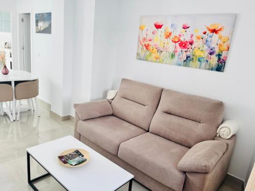a living room with a couch and a painting on the wall at Apartamentos Principado de Aracena II in Aracena