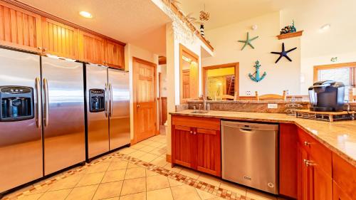 a kitchen with stainless steel appliances and wooden cabinets at Sea Shellter in Whalebone