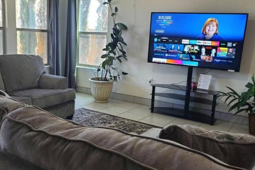 a living room with a couch and a flat screen tv at Lovely Room 1 Near San Marcosatx in Kyle