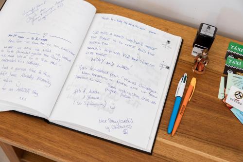 a desk with a book and pens and a notebook at Azurara Guesthouse in Azurara