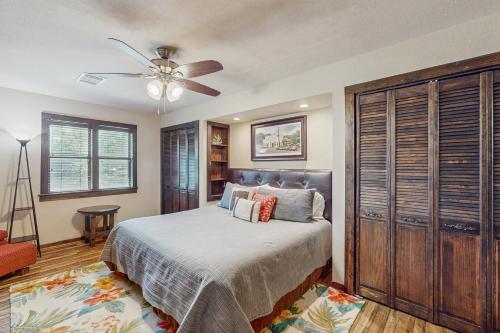 Un dormitorio con una cama y un ventilador de techo. en Clutter Falls Retreat - Main House, en Gruene