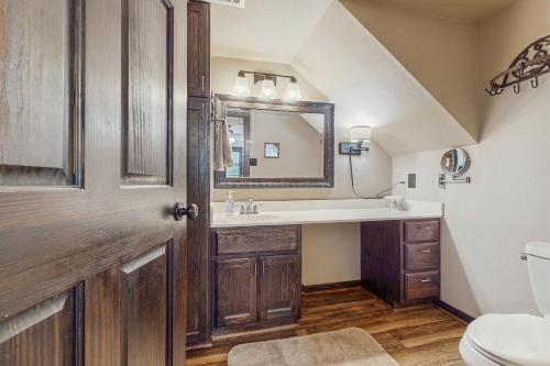 un baño con lavabo y espejo en Clutter Falls Retreat - Main House, en Gruene