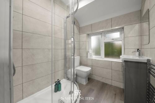 a bathroom with a shower and a toilet and a sink at Guest Fav - Luxury 5BR - Reading Centre - Monthly Stays - Parking in Earley