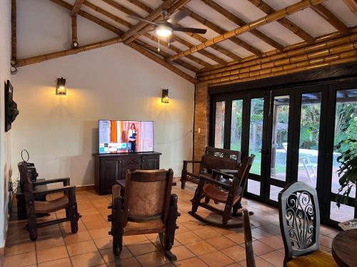 a living room with rocking chairs and a flat screen tv at Casa Panaca Portal 12 in Quimbaya