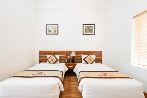 Tres camas en una habitación con paredes blancas. en Phoenix Mộc Châu Resort, en Mộc Châu