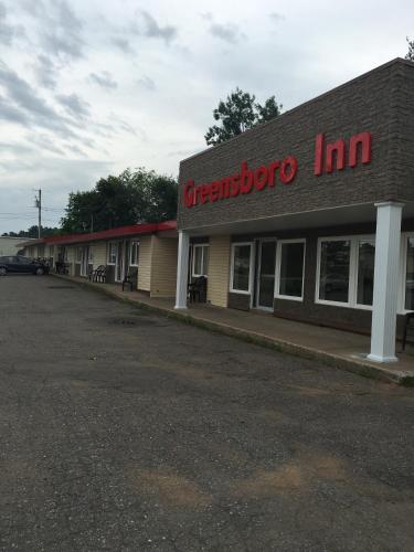 a gas station with a sign that reads greenboro inn at The Greensboro Inn in New Minas