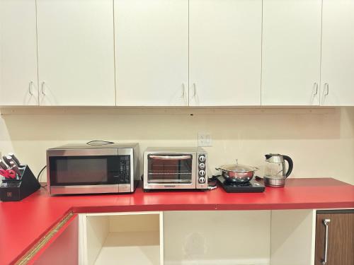 a kitchen with two microwaves on a red counter top at Zen House in Princeton