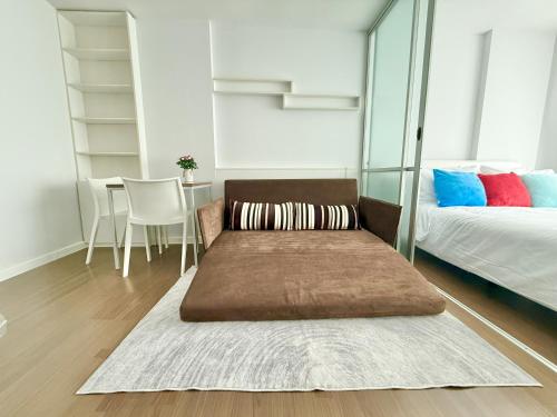a living room with a couch and a bed and a table at Spacious 1 Bedroom, with sofa bed and Balcony in Kathu
