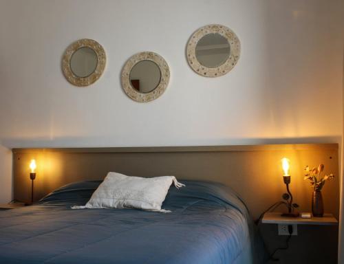 a bedroom with a bed with three mirrors on the wall at Departamentos Fleming, luminosos p hasta 4 personas in Paraná