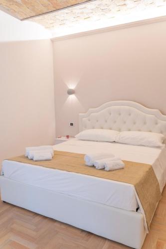 a white bedroom with a large bed with two white pillows at Celestino V in Sulmona