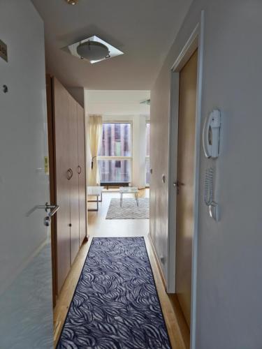 a hallway with a blue rug on the floor at Bright Studio in Rotermann Quarter - Noor Apartment in Tallinn