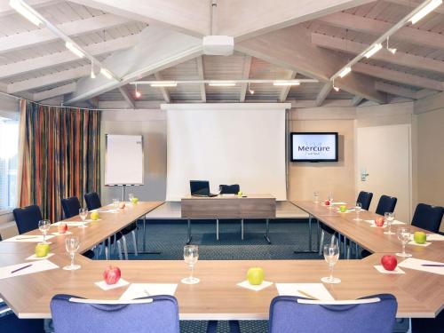 a meeting room with a long table and chairs at Mercure Hotel am Entenfang Hannover in Hannover