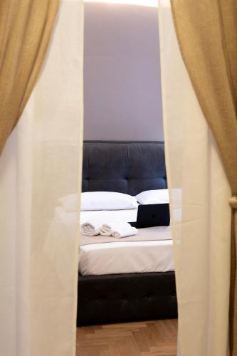 a bed with a black headboard and white sheets at Celestino V in Sulmona