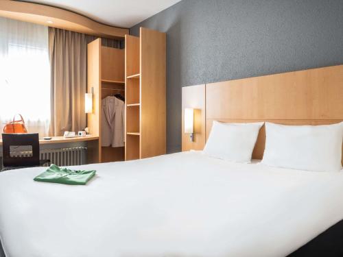a large white bed in a hotel room at ibis Genève Centre Gare in Geneva