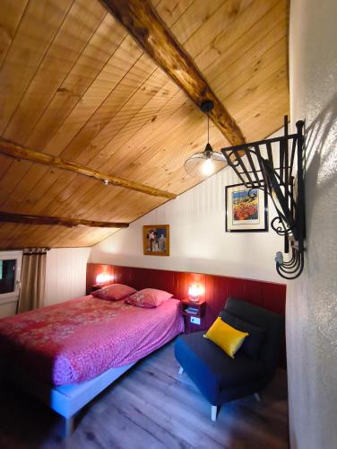 a bedroom with a bed and a chair at Le Mas De Ribard in Bréau-et-Salagosse