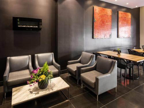 un restaurante con 2 mesas, sillas y flores en ibis Sydney World Square, en Sídney
