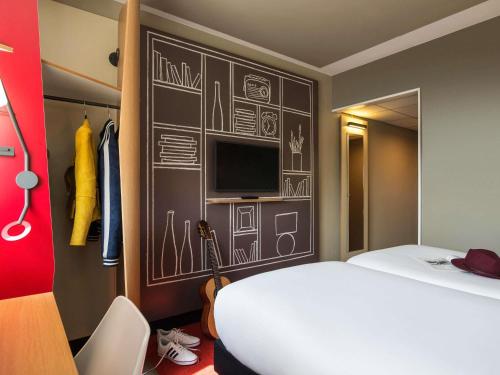 a bedroom with a bed and a wall with drawings on it at ibis Genève Centre Gare in Geneva