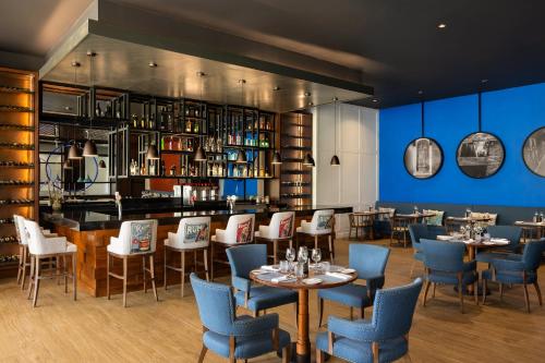a restaurant with tables and chairs and a bar at Dreams Cap Cana Resort & Spa - All Inclusive in Punta Cana