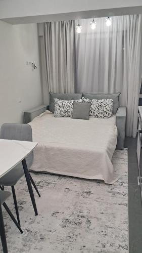 a bedroom with a bed and a desk and curtains at AIRPORT 24&24 CAR PARKING in Chişinău