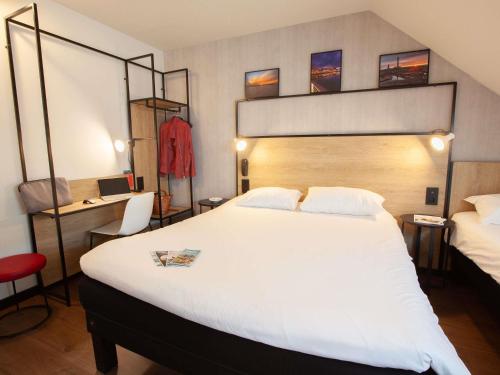 a hotel room with a large bed and a red chair at ibis Cherbourg La Glacerie in Cherbourg en Cotentin