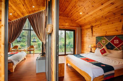 a bedroom with two beds in a wooden cabin at Phoenix Mộc Châu Resort in Mộc Châu