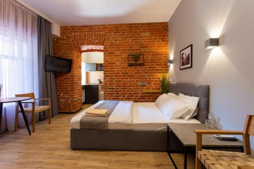 a bedroom with a bed and a brick wall at Нова квартира в центрі на Харківській набережній 3-4 in Kharkiv