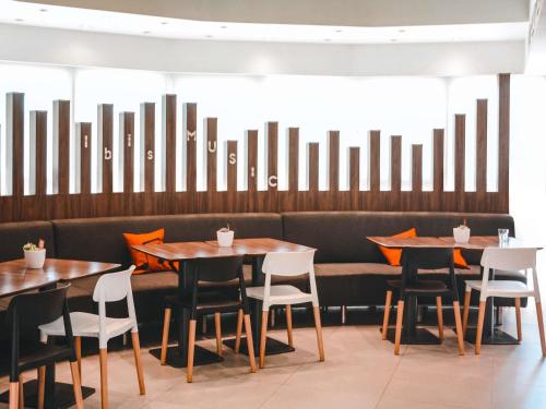 una fila di tavoli e sedie in un ristorante di ibis Mendoza a Mendoza
