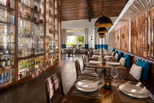 a restaurant with wooden tables and chairs and shelves of wine bottles at Dreams Cap Cana Resort & Spa - All Inclusive in Punta Cana