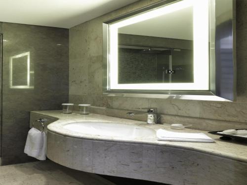 a bathroom with a sink and a large mirror at Sofitel Beirut Le Gabriel in Beirut