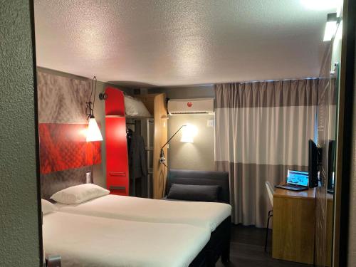 シャス・シュル・ローヌにあるIBIS Lyon Sud Chasse Sur Rhôneのベッドと机と椅子のあるホテルの部屋