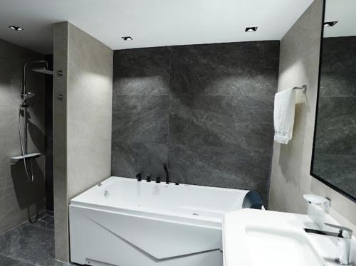 Un baño con bañera blanca y lavabo. en Pearl of Abu Dhabi, en Abu Dabi