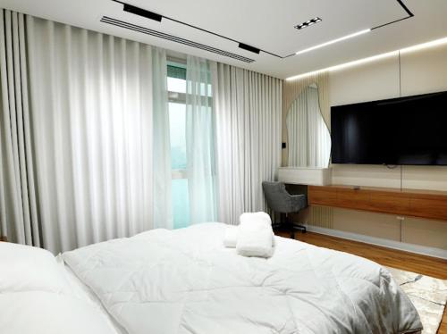 Un dormitorio con una cama y un televisor de pantalla plana. en Pearl of Abu Dhabi, en Abu Dabi