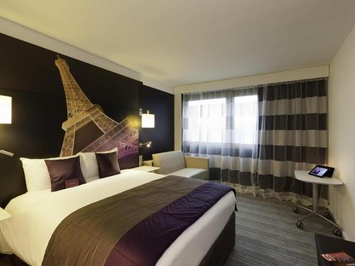 a hotel room with a bed and a tower on the wall at Mercure Paris Centre Tour Eiffel in Paris