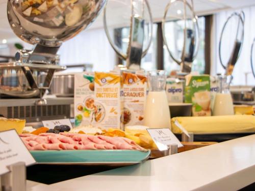 a counter with a plate of meat and other food at Mercure Paris Centre Tour Eiffel in Paris