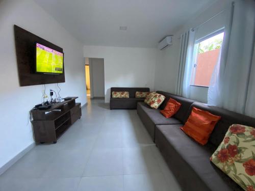 un soggiorno con divano e TV a schermo piatto di Tolentino - Casa de Praia a Santa Cruz Cabrália