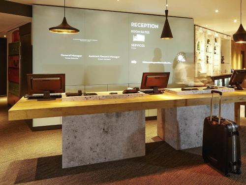 a lobby with a reception desk with a suitcase at ibis London Thurrock M25 in Grays Thurrock