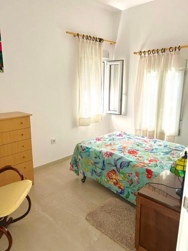 a bedroom with a bed and a dresser and windows at Isla Sicilia in Oliva